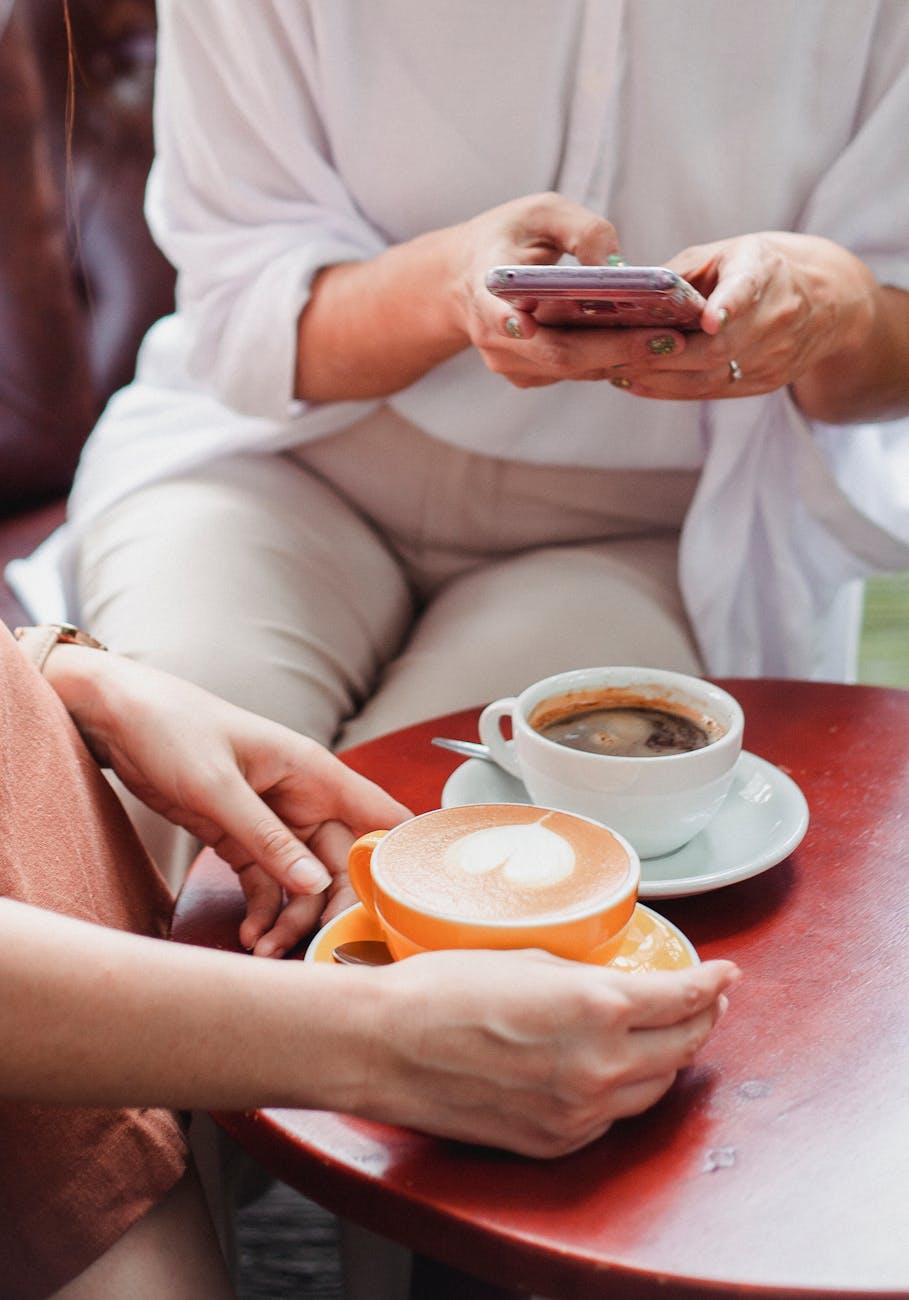 friends sitting at table with coffee in cafe